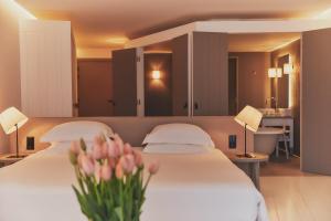 a hotel room with two beds and flowers on the bed at Hôtel Plage Palace & Spa in Palavas-les-Flots