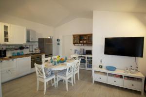a kitchen with a table and chairs and a television at La Casa dei Pesci in Budoni