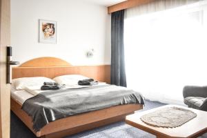a bedroom with a bed and a large window at Berghotel Almrausch in Berwang