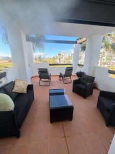 Una sala de estar con sofás y sillas y una mesa. en Casa Helen Las Terrazas de la Torre - Blue Sky Property, en Murcia