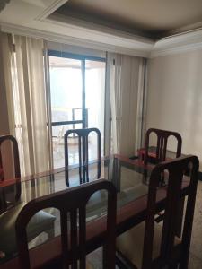 a dining room with a glass table and chairs at Edifício Thiago Augusto in Guarapari