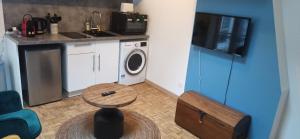 a small kitchen with a washing machine and a table at Studio GIVRY in Givry