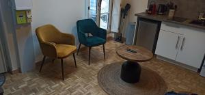 a living room with two chairs and a table at Studio GIVRY in Givry