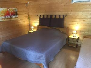 a bedroom with a bed in a wooden cabin at Mas de la Pinède ex-Les Arbousiers in Bollène