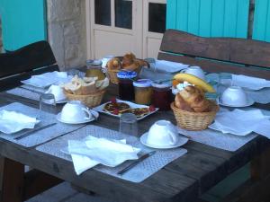 a table with bread and other food on it at Mas de la Pinède ex-Les Arbousiers in Bollène