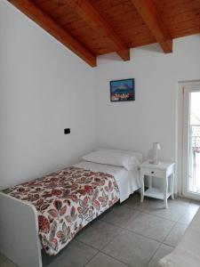 a bedroom with a bed and a table and a window at Casa Betty Lake View - Baveno in Baveno