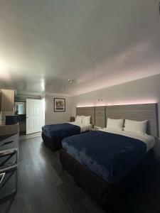 a hotel room with two beds and a television at Rodeway Inn in Ventura