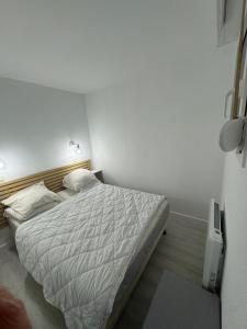 sypialnia z dużym łóżkiem z białą pościelą w obiekcie Superbe T2 à Lacanau 50m l’océan w mieście Lacanau