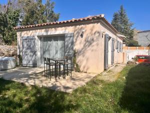 a table and chairs in front of a shed at Maison de village in Le Causse-de-la-Selle