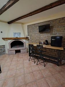 a living room with a stone fireplace and a television at Residenze del Bosco - The Lab in Tuscania