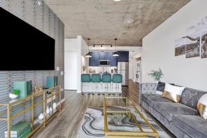 een woonkamer met een bank en een tv bij Golden Luxe Suite Downtown Nashville in Nashville