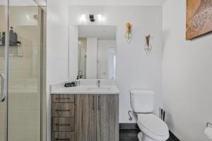 een badkamer met een wastafel, een toilet en een spiegel bij Golden Luxe Suite Downtown Nashville in Nashville