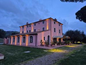 Un gran edificio blanco con luces. en Le Bozze "Il Frantoio" con piscina, Wi-Fi, posto auto, en Castagneto Carducci