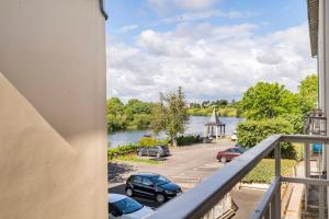 un balcón con vistas a un aparcamiento y a un río en Le Vin Quatre - Studio proche Dordogne et parking privatif, en Bergerac