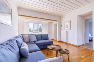 a living room with a blue couch and a table at Aretousa - Deluxe Pool Apartment in Skopelos Town +39 photos