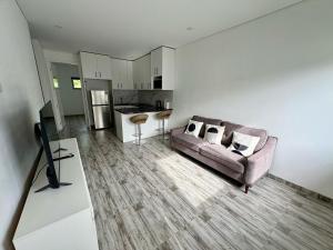 a living room with a couch and a kitchen at Cute Amazing Palace in Guildford