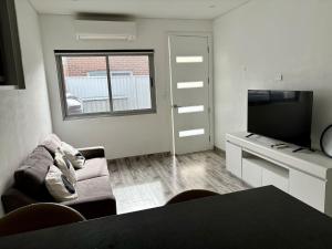 a living room with a couch and a flat screen tv at Cute Amazing Palace in Guildford +4 photos