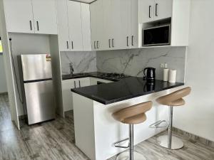 a kitchen with white cabinets and a black counter top at Cute Amazing Palace in Guildford