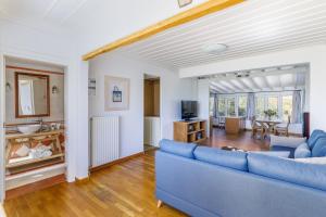 a living room with a blue couch and a table at Aretousa - Deluxe Pool Apartment in Skopelos Town
