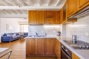 a kitchen with wooden cabinets and a living room at Aretousa - Deluxe Pool Apartment in Skopelos Town