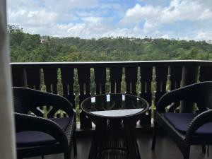 a balcony with chairs and a table and a view at Crosswinds Nature View Suite in Tagaytay