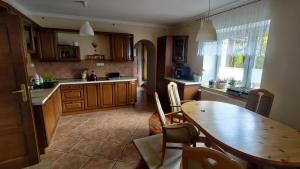 a kitchen with a wooden table and a dining room at Fajne Miejsce in Wambierzyce