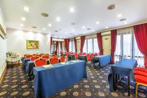 uma sala de conferências com mesas azuis e cadeiras vermelhas em Minerva Premier Hotel em Tessalônica