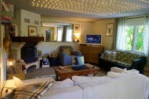 a living room with white couches and a fireplace at Au bord de l'eau in Tendu