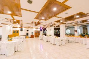 a large banquet hall with white tables and chairs at HAUS MALIBU Guesthouse & Restaurant in Malaybalay