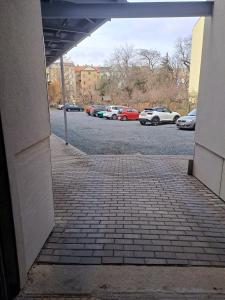 a brick walkway with cars parked in a parking lot at Apartman MWM Brno in Brno