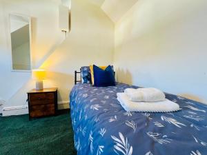 フェリックストウにある4-Bedroom House 5 mins to Beach & Parkingのベッドルーム1室(青いシーツと青い枕のベッド1台付)