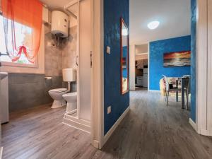 a bathroom with a toilet and a dining room at Pace in Bibione +30 photos