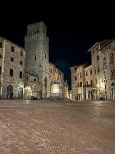 a large stone building with a tower at night at Home sweet home in San Gimignano