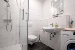 a bathroom with a toilet and a sink and a shower at Ferienhaus Schwalbe in Berumbur +12 photos