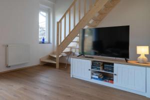 a living room with a flat screen tv on a cabinet at Ferienhaus Schwalbe in Berumbur