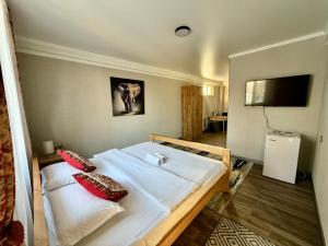 a bedroom with a large white bed with red pillows at Salamat Hotel in Bishkek