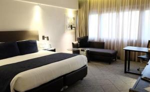 a hotel room with a bed and a couch and a chair at Sweet home in Karawang +15 photos