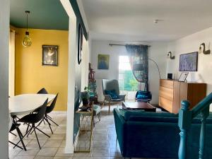 a living room with a couch and a table and chairs at Villa Yollande in Arcachon