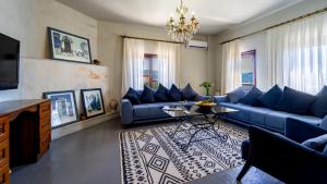 een woonkamer met blauwe banken en een kroonluchter bij Villa CANAN in Kas