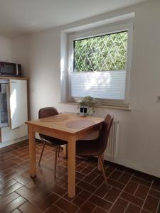 a table and two chairs in a room with a window at Moderne Ferienwohnung mit privatem Eingang - ROSA in Kalletal