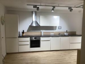 a kitchen with white cabinets and a stove top oven at Schöne FeWo im Illertal in Oberopfingen