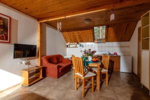 a kitchen and dining room with a table and chairs at Dom Gościnny W Lesie in Pobierowo