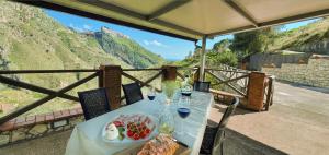 a table with a plate of food on top of a mountain at Villa Giardino Aloe - Rifugio nella Natura Siciliana, Lontano dal Caos di Taormina in Castelmola