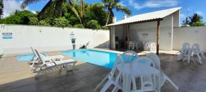 a patio with chairs and a swimming pool at Mar Calmo, 150m da praia in Santa Cruz Cabrália
