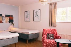 a bedroom with a bed and a chair and a table at Sundsmåla Landsbygdshotell in Brokind