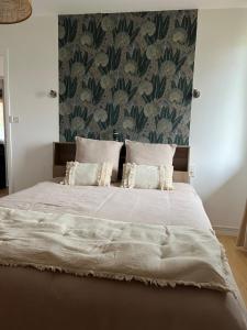a bedroom with a large bed with white sheets at Appartement 4 pers avec jardin & parking-calme-proche Clermont in Royat