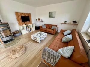 a living room with a couch and a tv at Ferienhaus im Thüringer Wald in Struth-Helmershof