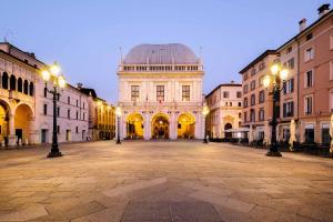a large building with lights in the middle of a street at MagentA NesT - Loft&Charme in Brescia