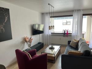 a living room with a couch and a table at Ferienwohnung am Waltenberg in Winterberg