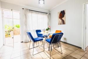 a dining room with a table and blue chairs at House 22 on Alice in Centurion